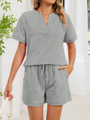 Gray loungewear shorts with drawstring waist and a matching short-sleeve top with V-neck.