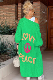 Green maxi knit cardigan with "LOVE PEACE" and peace sign graphic, long sleeves, open front