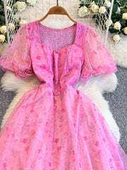 Pink floral print maxi dress with sweetheart neckline, puff sleeves, and smocked bodice.