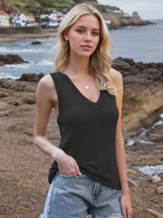 Black knit tank top with deep V-neck and tie straps, styled with denim shorts.