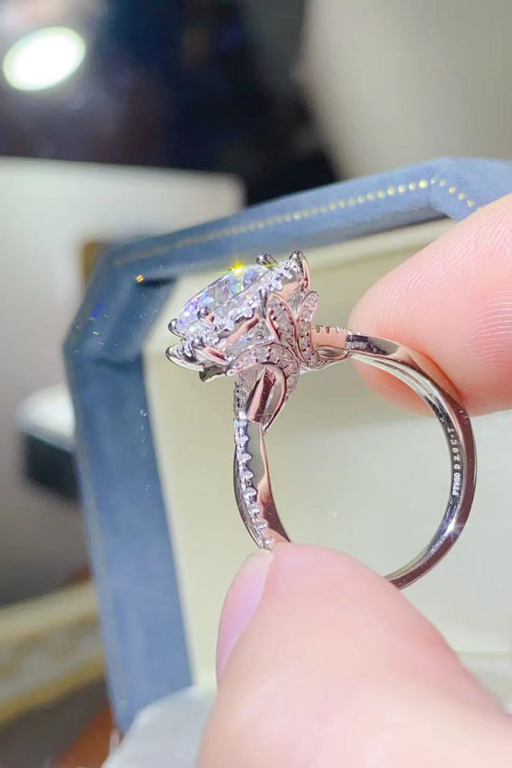 Silver moissanite engagement ring with halo setting and intricate band detail.