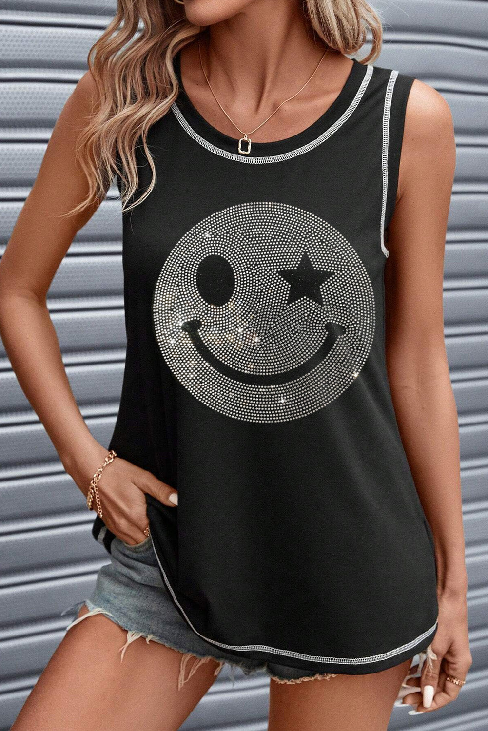 Black rhinestone smiley face tank top with contrast stitching and a star eye detail.
