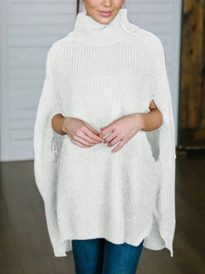 White acrylic turtleneck sweater with cape sleeves and ribbed texture.