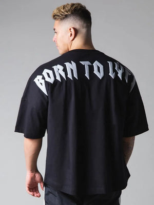 Black oversized graphic tee with white "BORN TO LY" text on back.