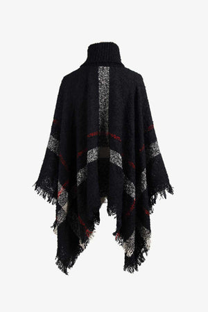 Black plaid turtleneck cape with fringe detail and textured acrylic knit.