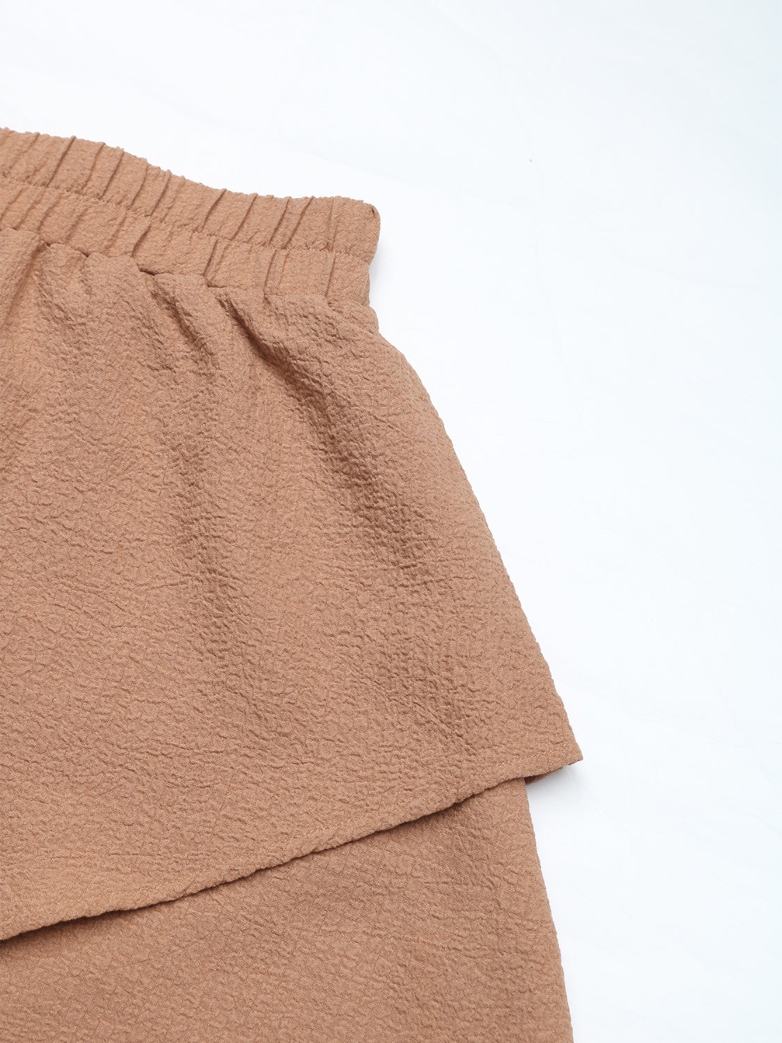 Camel tiered ruffle waistband shorts with textured fabric and elastic waist.