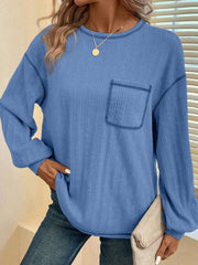 Blue ribbed knit sweater with contrast stitching on the chest pocket and crew neckline.