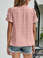 Pink textured puff sleeve dot blouse with short sleeves and a casual cut.