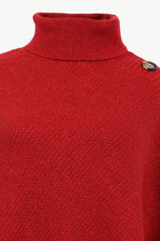 Deep red acrylic turtleneck poncho with button detail on shoulder