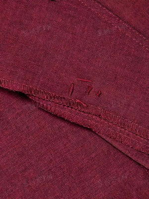 Burgundy vest detail showing stitching and raw edges.