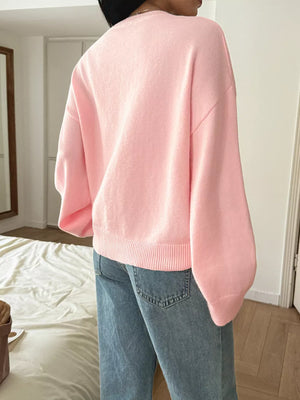 Blush pink V-neck knit sweater with ribbed hem and cuffs.