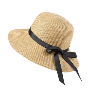 Wide brim sun hat in beige straw with a black ribbon bow detail.