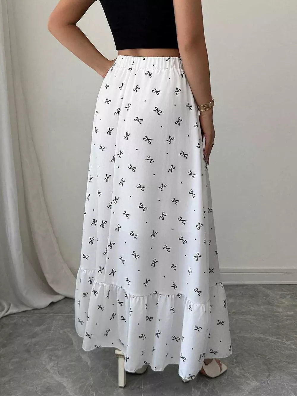 White maxi skirt with black bowknot print and ruffled hem.