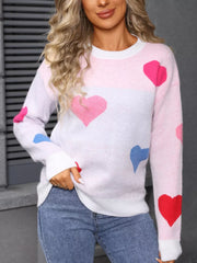 Pink and white acrylic heart pattern sweater with round neck and long sleeves.