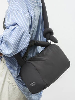Padded knot shoulder bag in dark gray with a knotted strap detail.