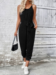 Black chain-strap gathered waist jumpsuit with tie belt and cuffed ankles.