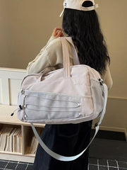 Grey nylon travel bag with adjustable strap and bungee cord details.