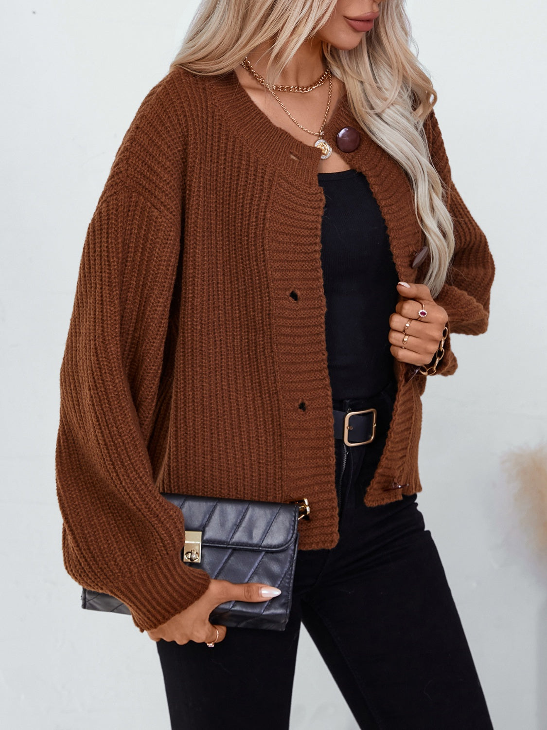 Brown ribbed knit button-up cardigan with round neckline and balloon sleeves.