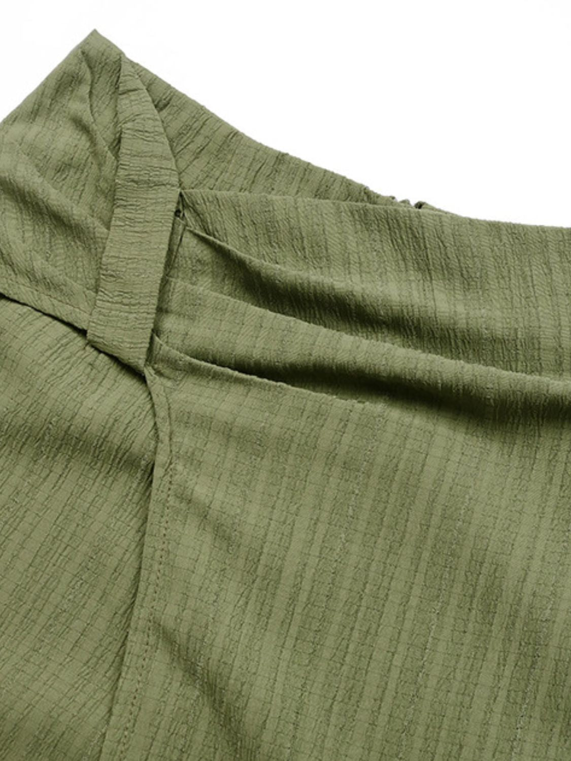 Matcha green skort shorts with draped knot front detail and textured fabric.