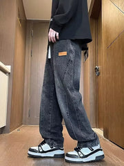 Dark gray vintage wash straight-leg jeans with a leather logo patch and contrast stitching.