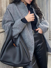 Gray boucle cocoon jacket with snap closure and stand-up collar, styled with black top and leather pants.