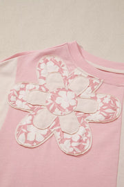 Pink cotton t-shirt with a large applique flower featuring a floral print and cream accents.