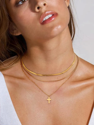 Gold layered necklace with herringbone chain and cross pendant