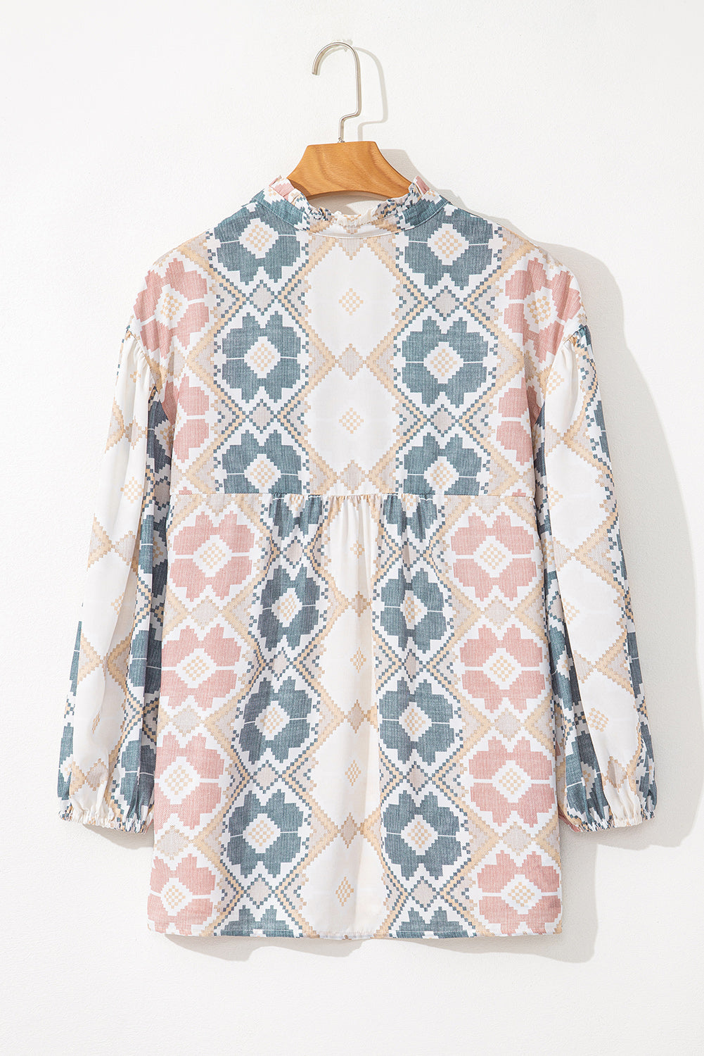 Floral geometric print blouse with ruffled neckline and gathered waist.