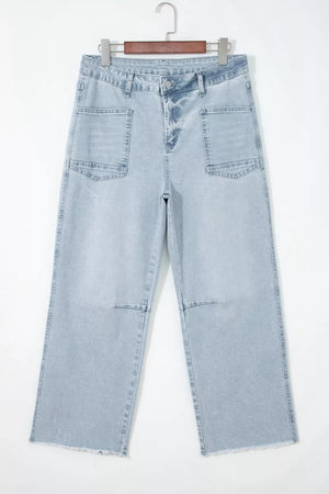 Light wash denim jeans with raw hem and large utility pockets.