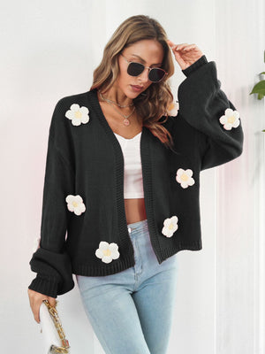 Black knit cardigan with floral appliqué and balloon sleeves.