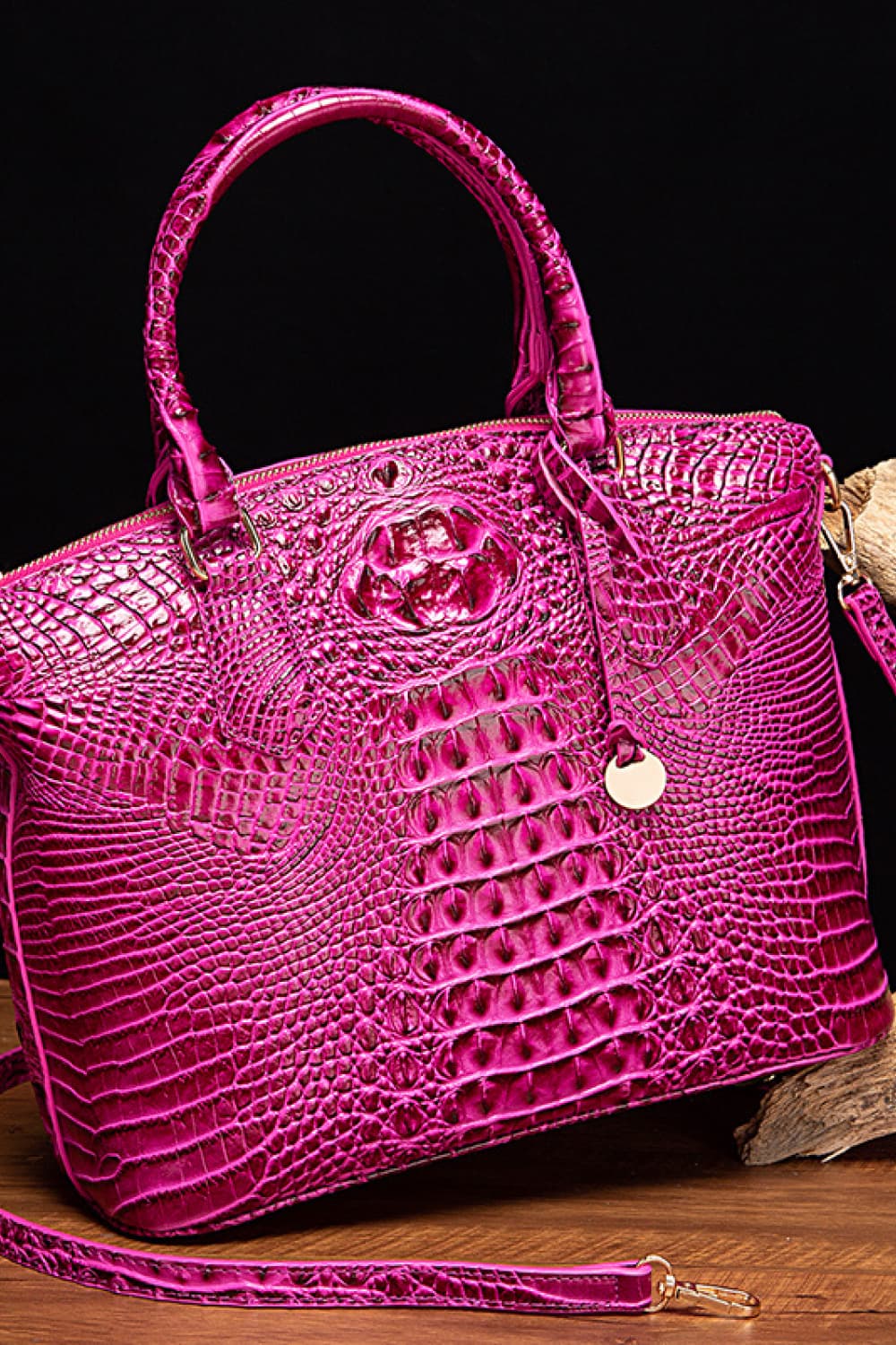 Fuchsia pink crocodile embossed satchel bag with top handle and gold hardware detail.