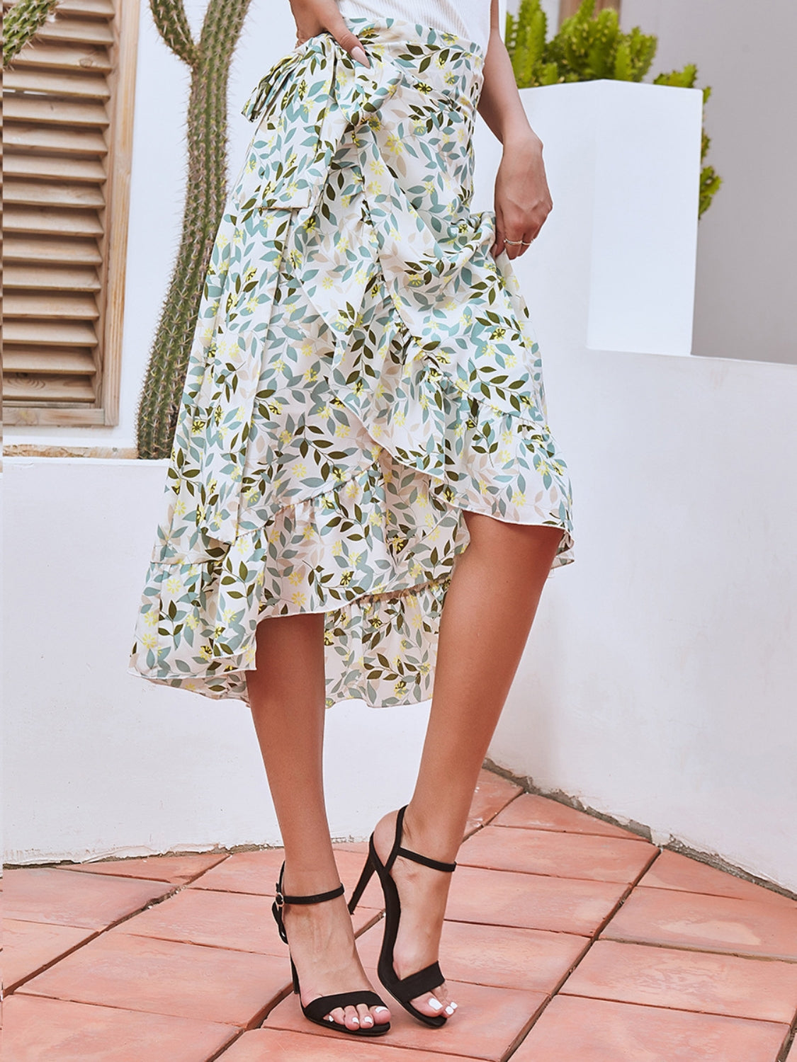 Asymmetric wrap skirt with leaf print in Gum Leaf, featuring ruffled hem and tie waist.