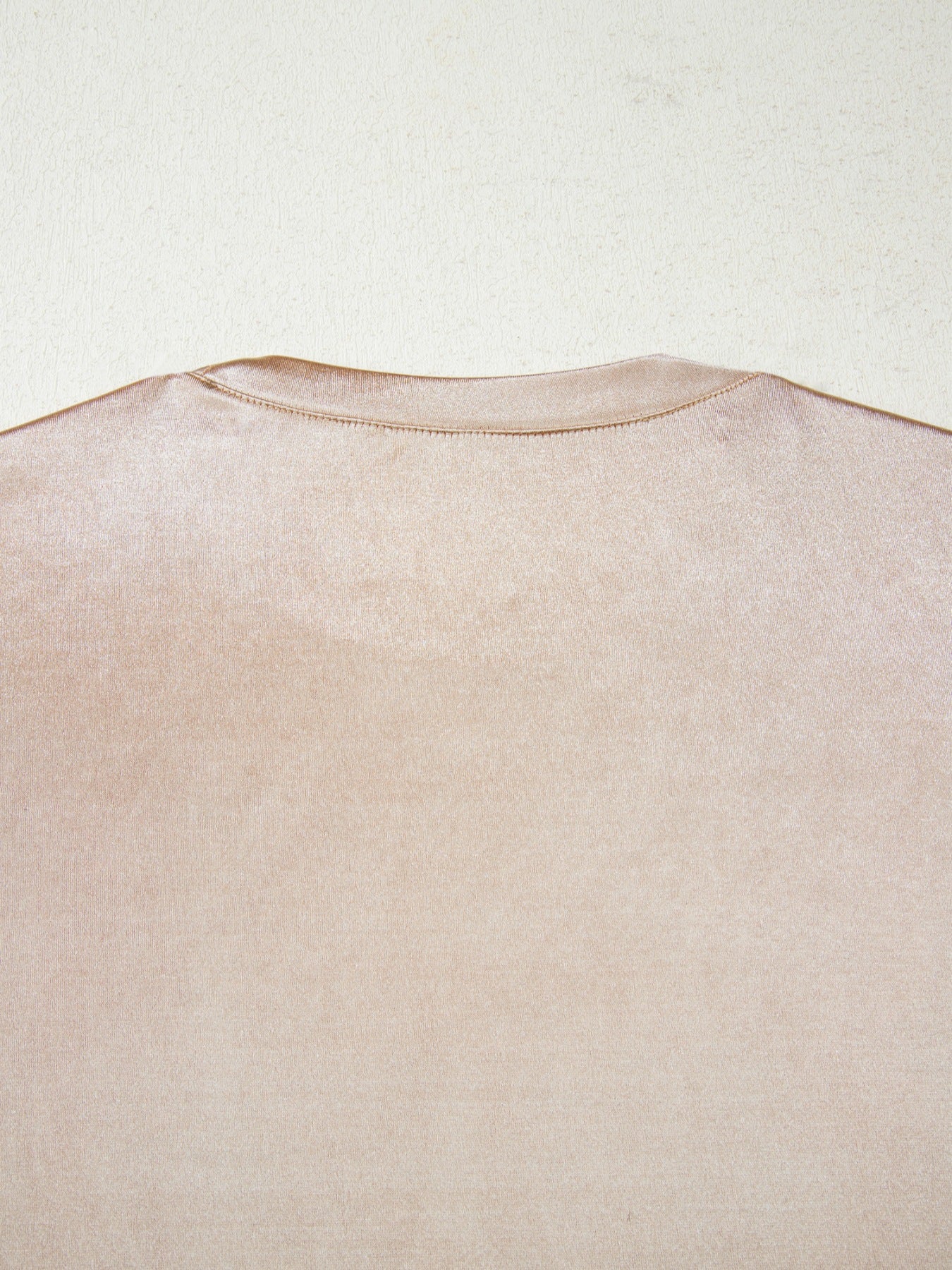 Sleeveless champagne tank top with a lustrous metallic finish and crew neckline.