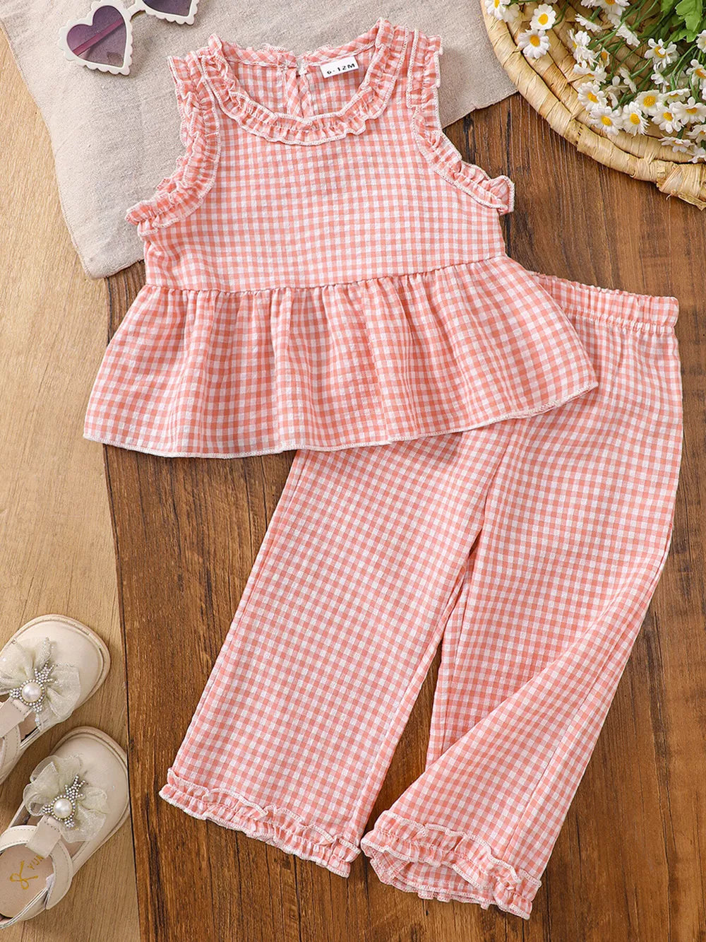 Pink gingham baby set with ruffled neckline and hemmed pants.