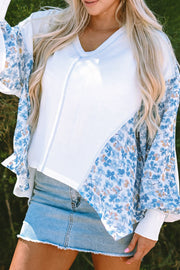 White waffle knit blouse with blue floral print sleeves and V-neck