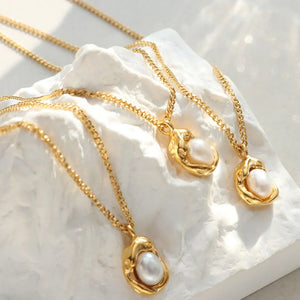 Gold pearl charm necklace with delicate chain and organic pendant.