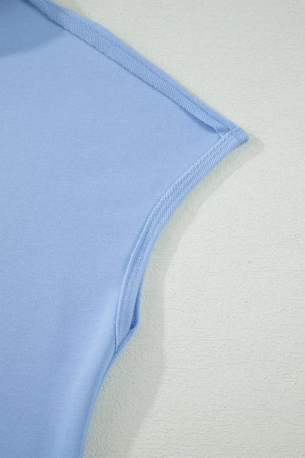 Light blue sleeveless polo top detail with contrast trim and stitching