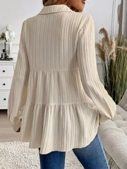 Cream textured tiered button-down shirt with long sleeves and a collared neckline.