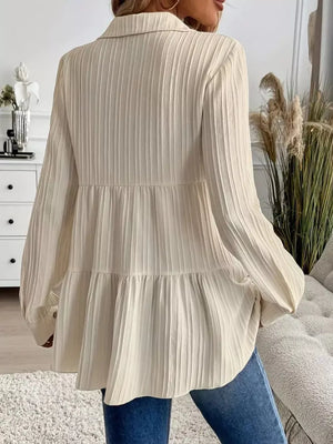 Cream textured tiered button-down shirt with long sleeves and a collared neckline.