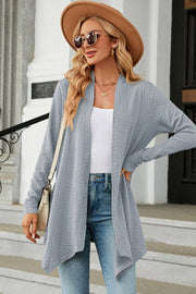 Light blue textured knit cardigan with asymmetrical drape front and long sleeves.