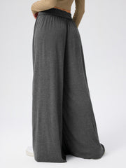 Dark gray jersey wide-leg trousers with elastic waistband and drape front detail.