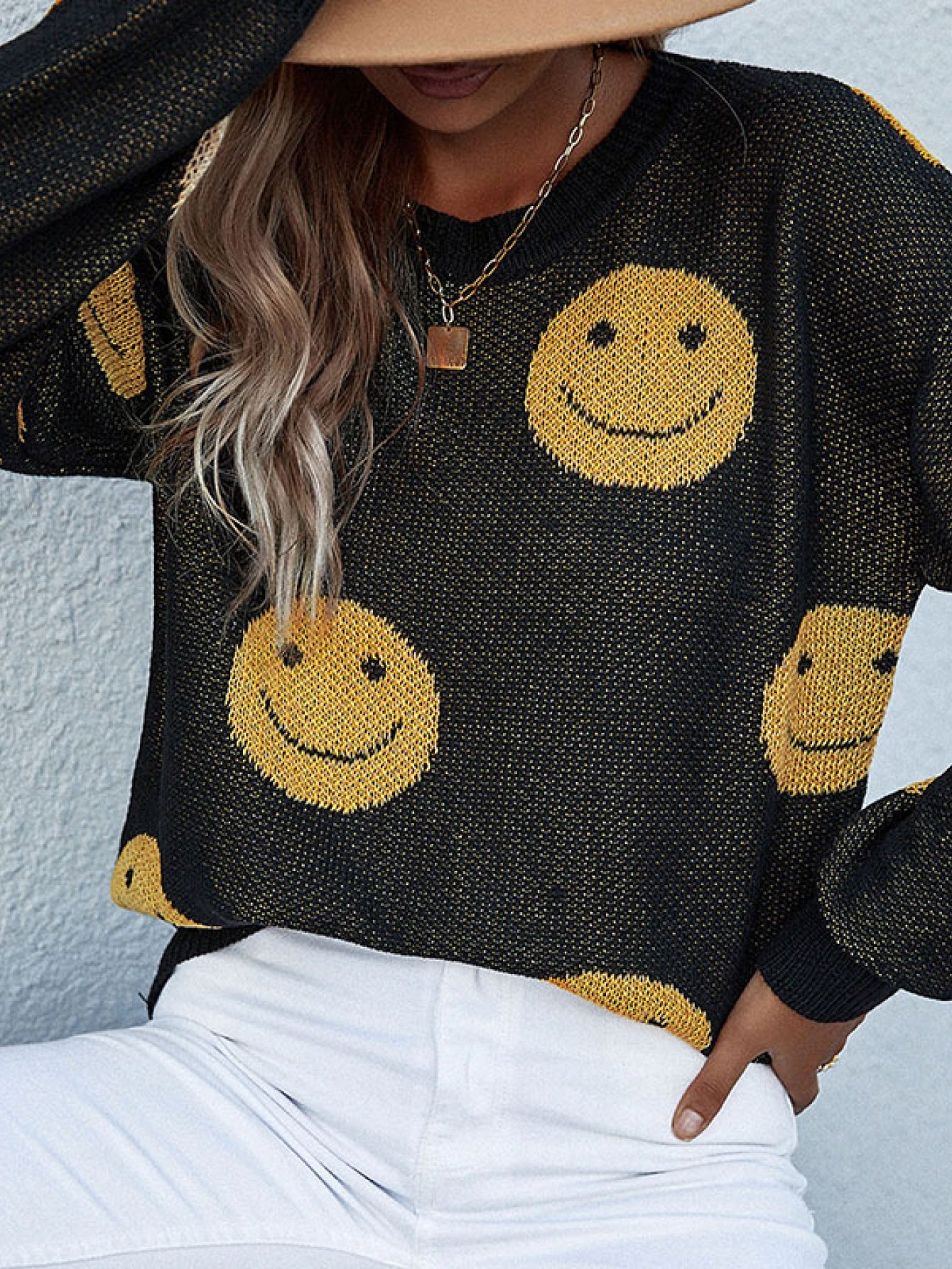 Black smiley face jacquard knit sweater with a crew neck.