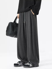 Relaxed fit dark gray sweatpants with drawstring and pockets.