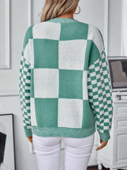 Checkerboard knit sweater in turquoise and white with a crew neck and long sleeves.