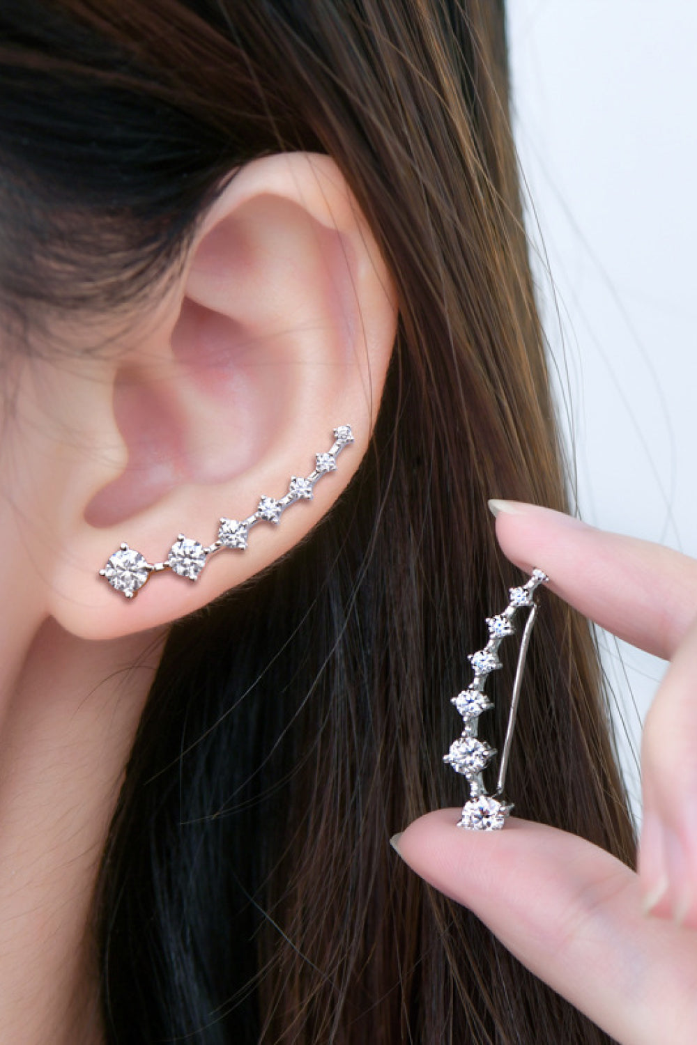 Silver ear climbers with clear cubic zirconia stones ascending the ear