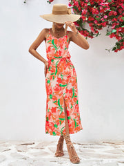 Floral print midi dress with button-down front, spaghetti straps, elastic waist, and thigh-high slit.