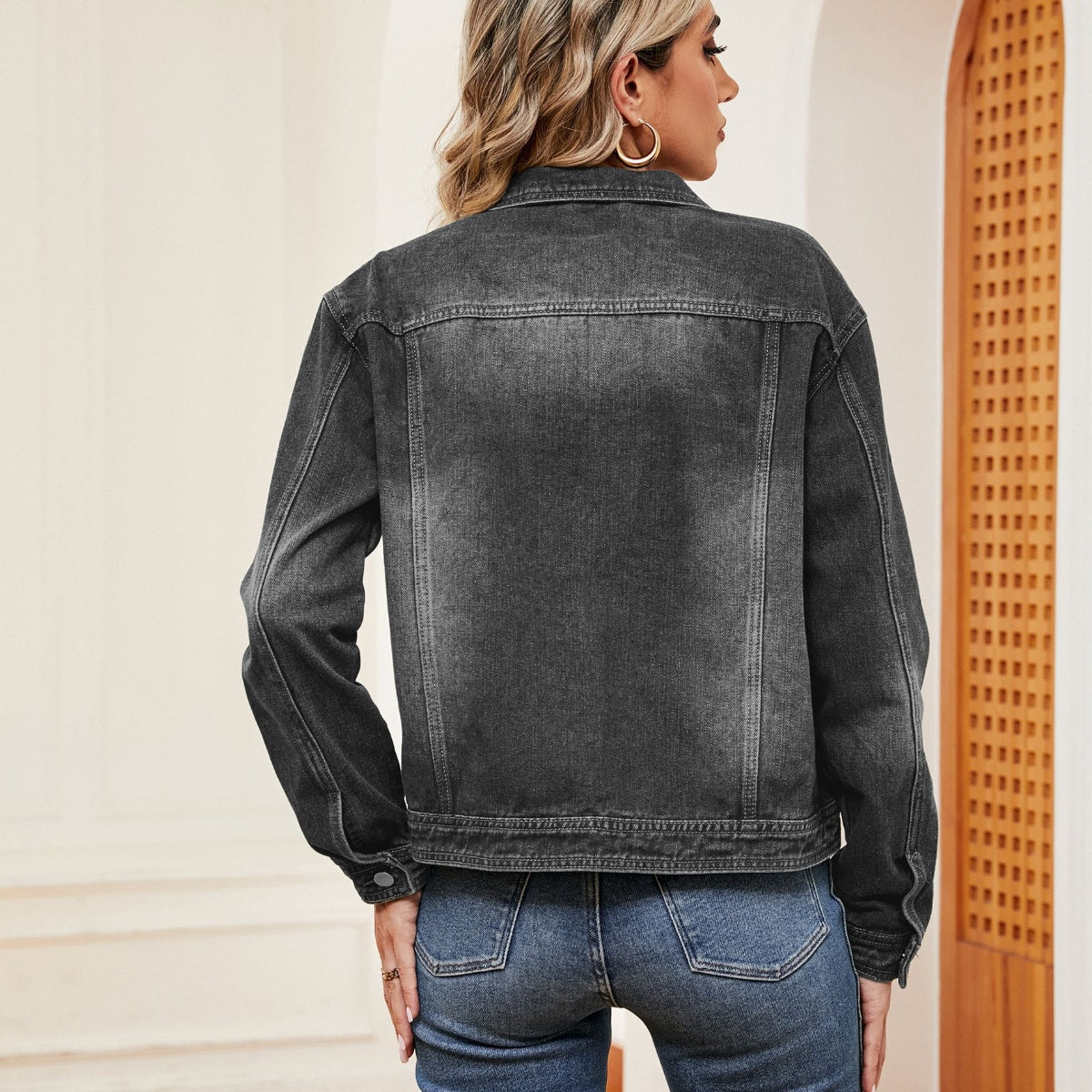 Dark wash faded denim trucker jacket with button cuffs and collar detail.