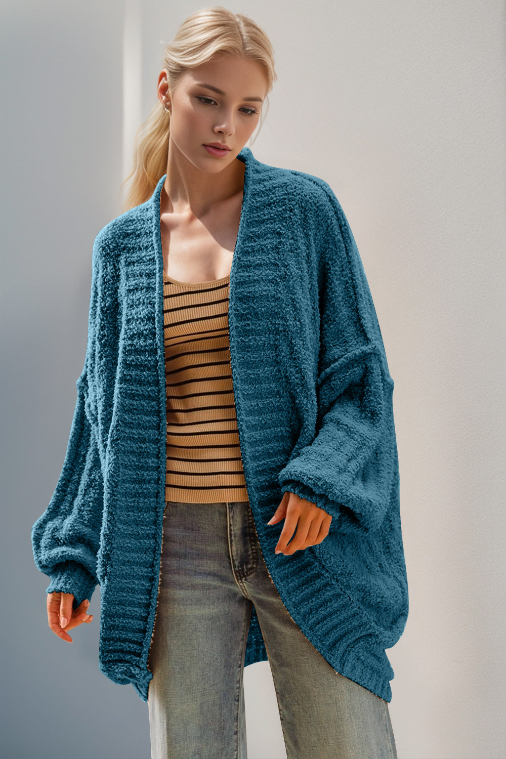 Cerulean textured bouclé cocoon cardigan with balloon sleeves and open front, styled with a striped tank top.