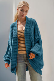 Cerulean textured bouclé cocoon cardigan with balloon sleeves and open front, styled with a striped tank top.