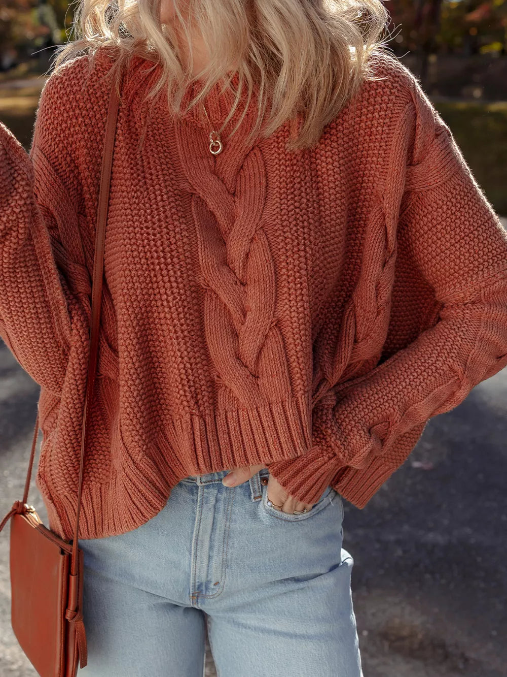 Chunky oversized cable-knit sweater in rust, with a cropped length and textured acrylic blend.